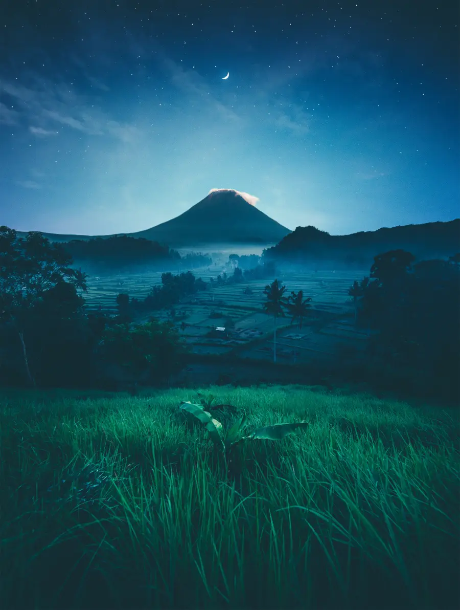 Paisaje nocturno con volcán y campos